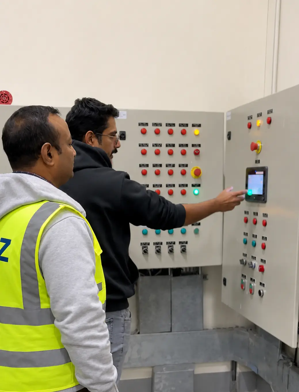 Kenz electrical supervisors commissioning complex main switchgear panel at NC2 Base Camp work in NEOM
