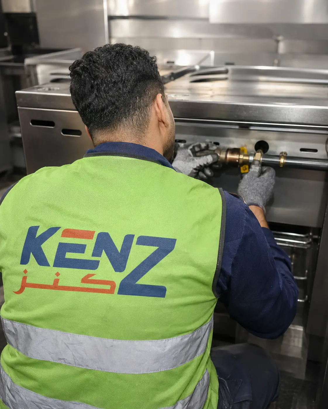 Kenz technician connecting industrial gas lines to commercial kitchen equipment