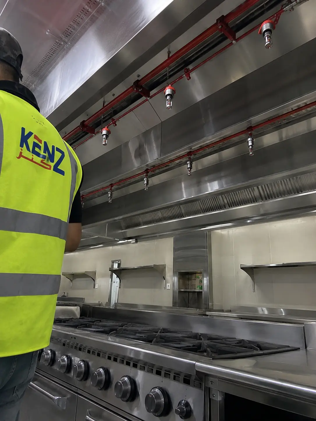 Red fire suppression pipes installed over commercial kitchen stove
