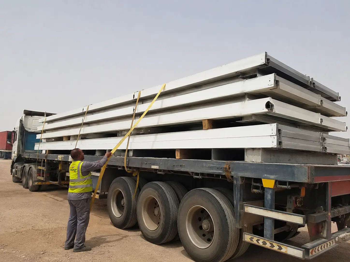 Flatbed truck loaded with Kenz flat-pack modular building components in Saudi Arabia