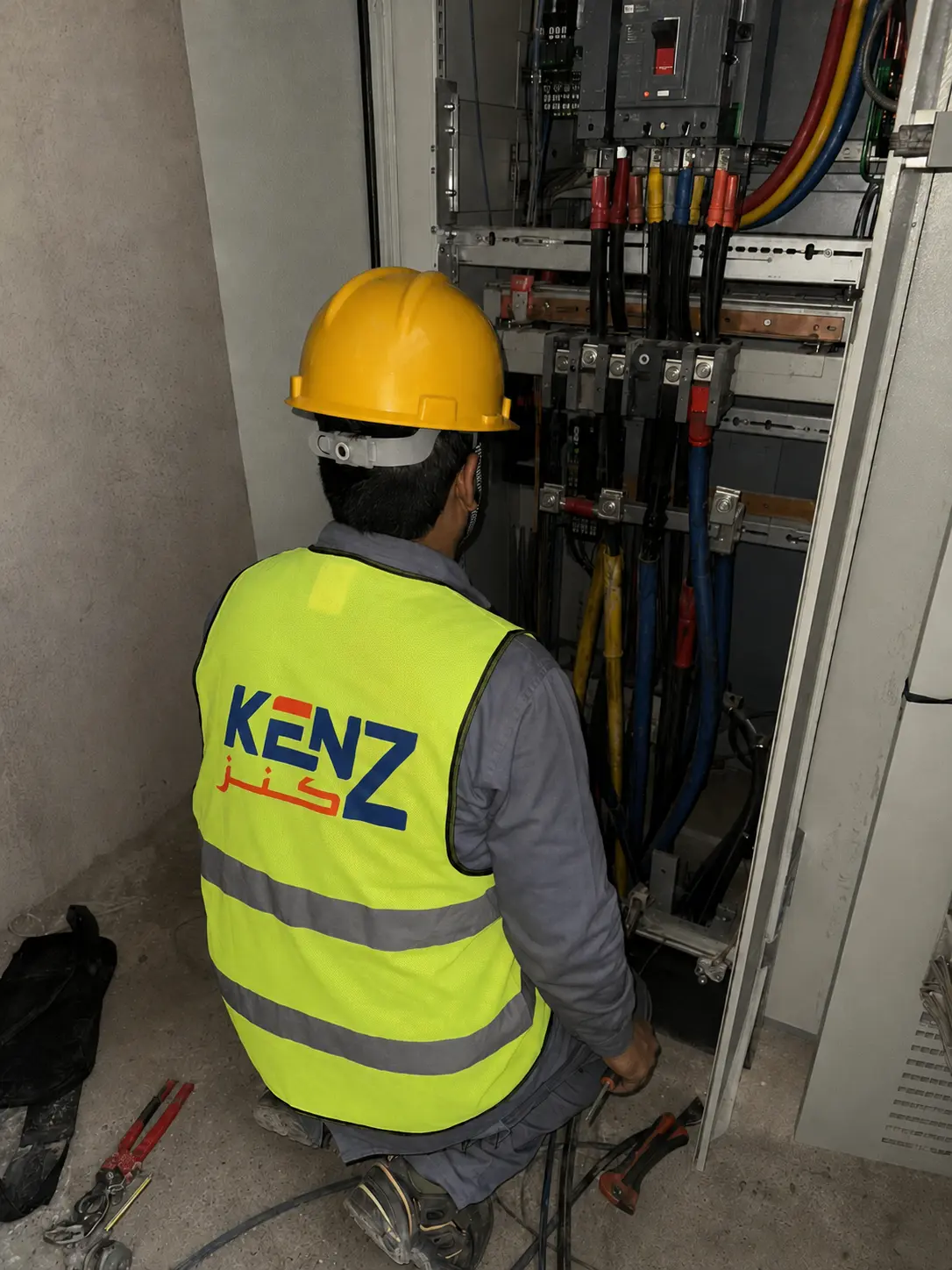 Electrical technician terminating thick cables in Main Distribution Panel (MDP)