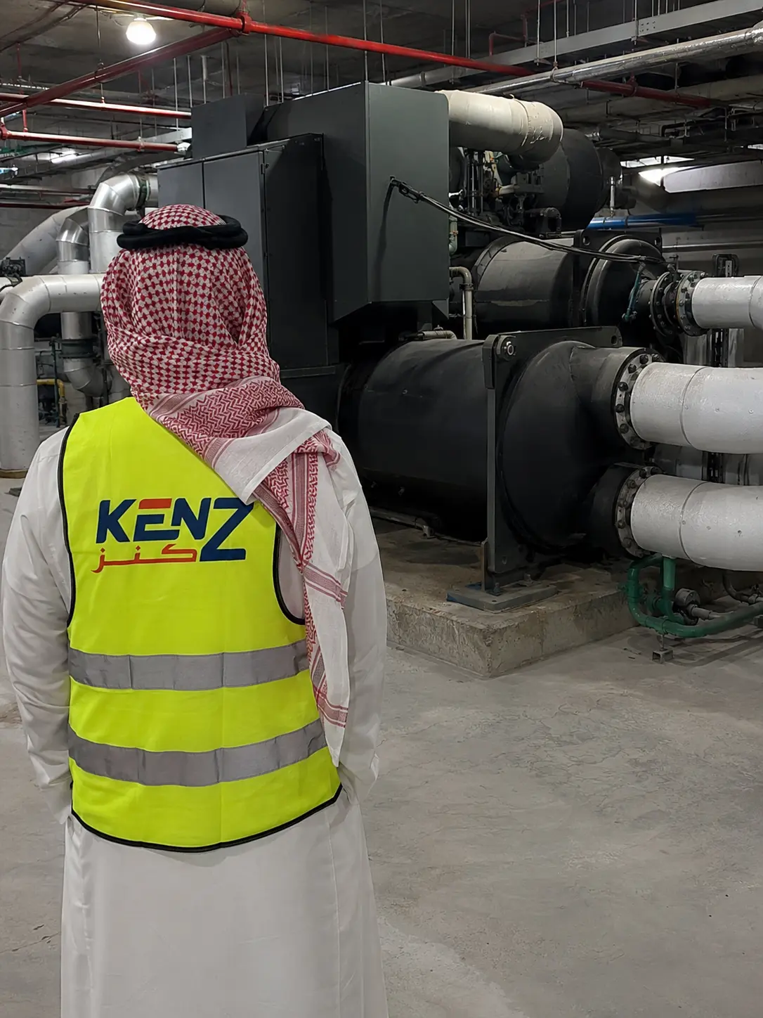 Saudi Project Manager inspecting massive industrial water chiller plant room in Riyadh