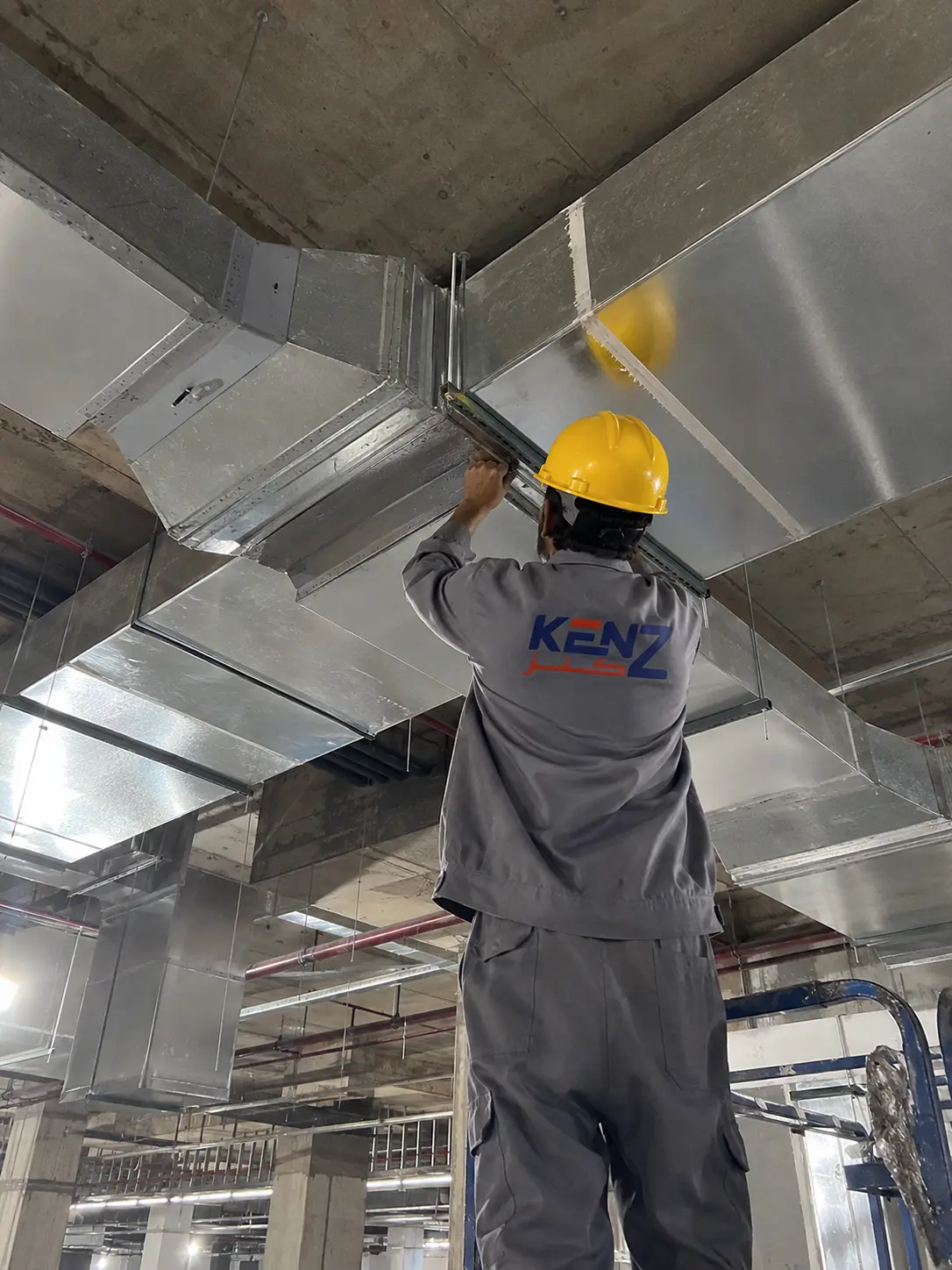 Kenz mechanical technician installing galvanized HVAC ductwork